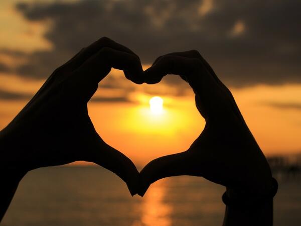 Bild vergrößern: Zwei Hnde formen ein Herz vorm Sonnenuntergang.