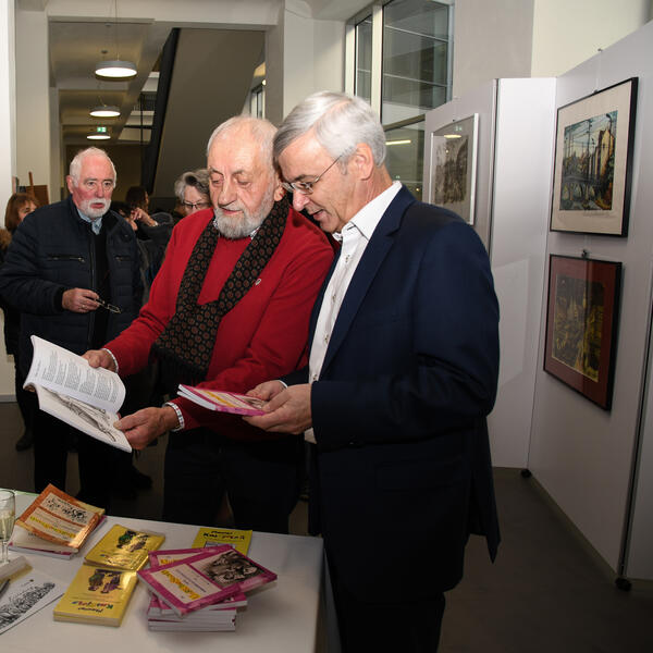 Bild vergrößern: Eines seiner neu erschienenen Bücher signierte er für Landrat Rolf Keil.