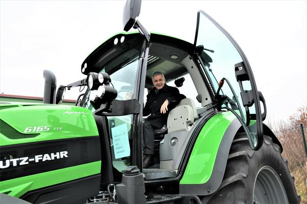 Bild vergrößern: Landrat Rolf Keil in einem großen grünen Traktor, zu Besuch im Mechelgrüner Technik Zentrum.