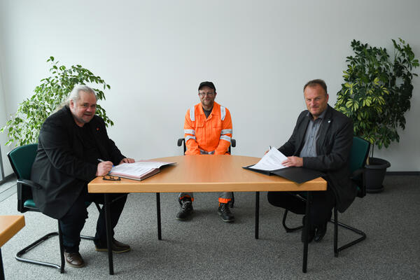 Bild vergrößern: Lars Beck, Geschäftsführer der KEV (rechts) und Andreas Schubert, Fachbereichssekretär ver.di (links), unterzeichnen die Tarifverträge.