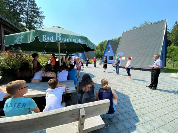 Bild vergrößern: Deutsche und tschechische Kinder und Jugendliche lauschen gespannt den Grußworten der Redner, die bei strahlendem Sonnenschein das 29. Jugendsommerlager der Euregio Egrensis eröffnet haben