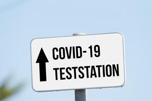 Bild vergrößern: Das Bild zeigt ein Schild auf dem steht: "COVID-19 Teststation"