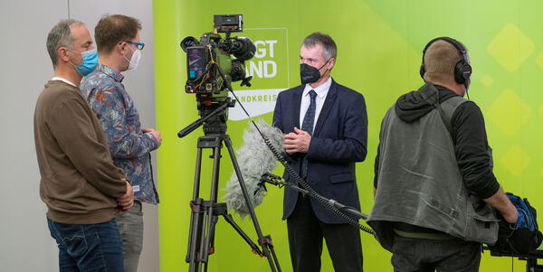 Das Bild zeigt den Beigeordneten und Vize-Landrat des Vogtlandkreises, Dr. Uwe Drechsel bei einem Interview vor der Kamera eines dreiköpfigen Fernsehteams. 