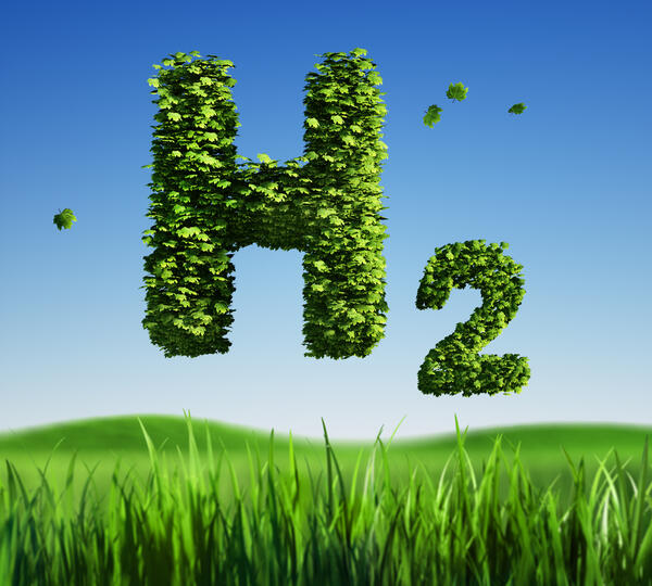 Das Bild zeigt blauen Himmel und eine grüne Wiese - darüber in grasgrüner Schrift H2: die chemische Formel für Wasserstoff. 