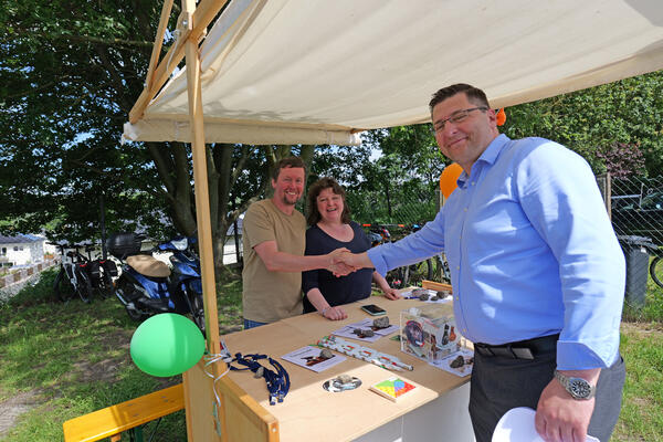 Auf dem Bild ist der Landrat bei der Begr&uuml;&szlig;ung von zwei Leuten am Stand zu sehen.