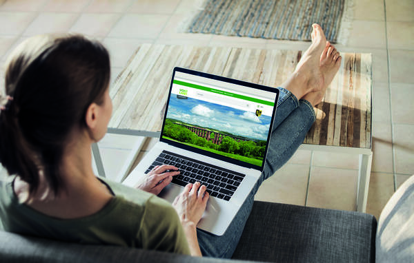 Auf dem Bild sieht man eine Frau mit einem Laptop auf den Knien. Auf dem Bildschirm ist die Webseite www.vogtlandkreis.de geöffnet.
