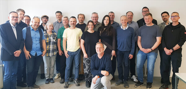 Das Bild zeigt eine Gruppe von Menschen stehend.