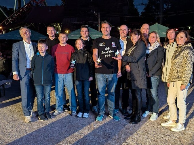 Die Gewinner stehen zusammen und zeigen ihre Pokale.