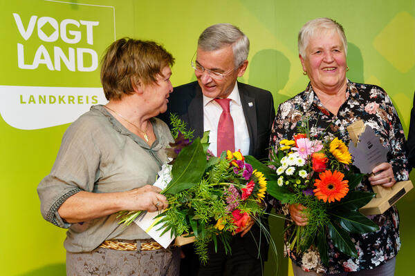 Bild vergrößern: Landrat Rolf Keil überreicht zur Ehrenamtsgala 2019 zu Ehrenden einen Blumenstrauss auf der Bühne.