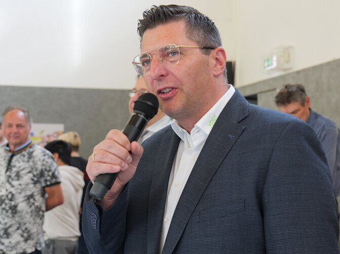 Landrat Thomas Hennig hat ein Mikrofon in der Hand und h&auml;lt ein Gru&szlig;wort.
