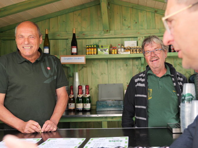 Zwei Betreiber eines Bierstandes lachen.