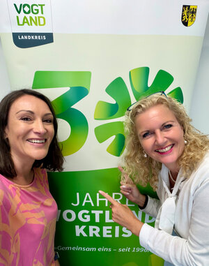 Bild vergr&ouml;&szlig;ern: Das Bild zeigt Podcastmoderatorin Madlen Schulz und Kulturchefin Silke Fischer vor dem RollUp zu 30 Jahren Vogtlandkreis.