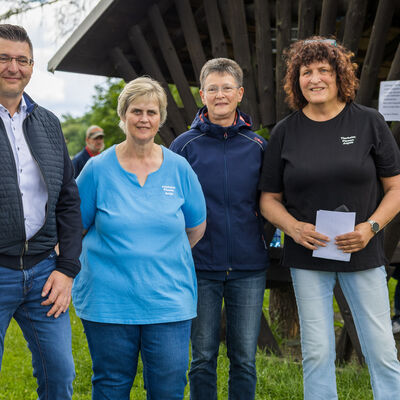 Bild vergr&ouml;&szlig;ern: Vier Personen stehen auf dem Gel&auml;nde des Tierheims Plauen vor einem &uuml;berdachten Sitzbereich. Zwei Frauen tragen T-Shirts mit der Aufschrift Tierheim Plauen.