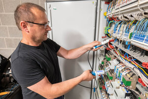 Bild vergr&ouml;&szlig;ern: Ein Mann steht am Schaltschrank.