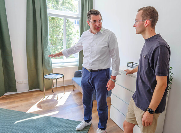 Bild vergr&ouml;&szlig;ern: Zwei M&auml;nner stehen in einer Wohnung
