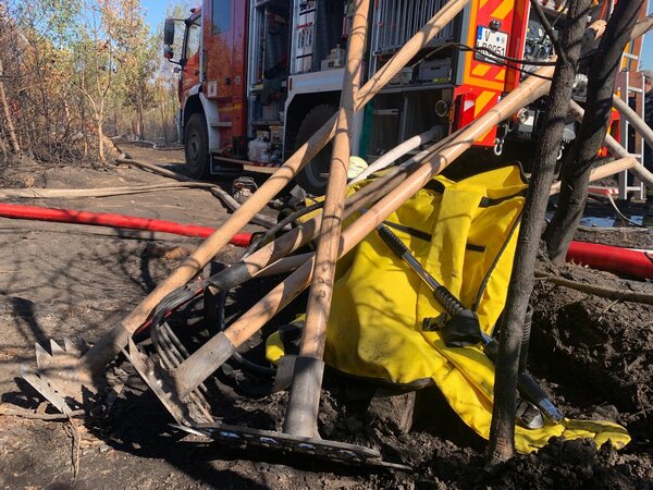 Bild vergr&ouml;&szlig;ern: Das Bild zeigt verschiedenes Handwerkszeug zur Waldbrandbek&auml;mpfung, darunter Wiederhopfhacken und L&ouml;schwasserrucks&auml;cke.