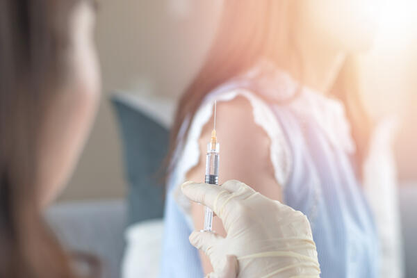 Bild vergrößern: Auf dem Foto sieht man, wie einer Frau eine Impfung verabreicht wird.