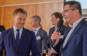 Bild vergr&ouml;&szlig;ern: Das Bild zeigt den s&auml;chsischen Ministerpr&auml;sidenten Michael Kretschmer und Landrat Thomas Hennig. Der Landrat spricht ins Mikrofon.