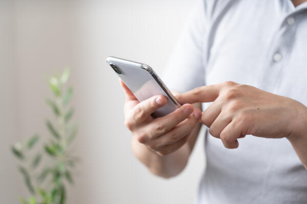 Bild vergrößern: Das Bild zeigt eine Person, die auf dem Bildschirm eines Smartphones tippt.