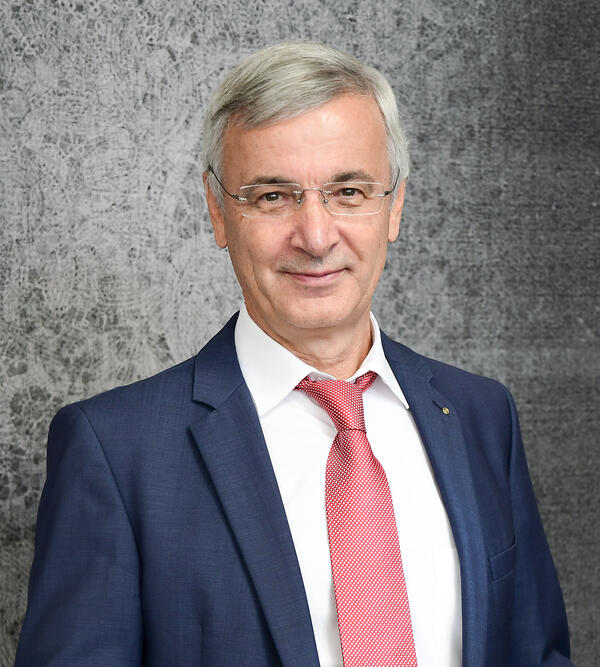 Landrat Rolf Keil vor einer grauen spitzen-besetzten Wand im Horten.